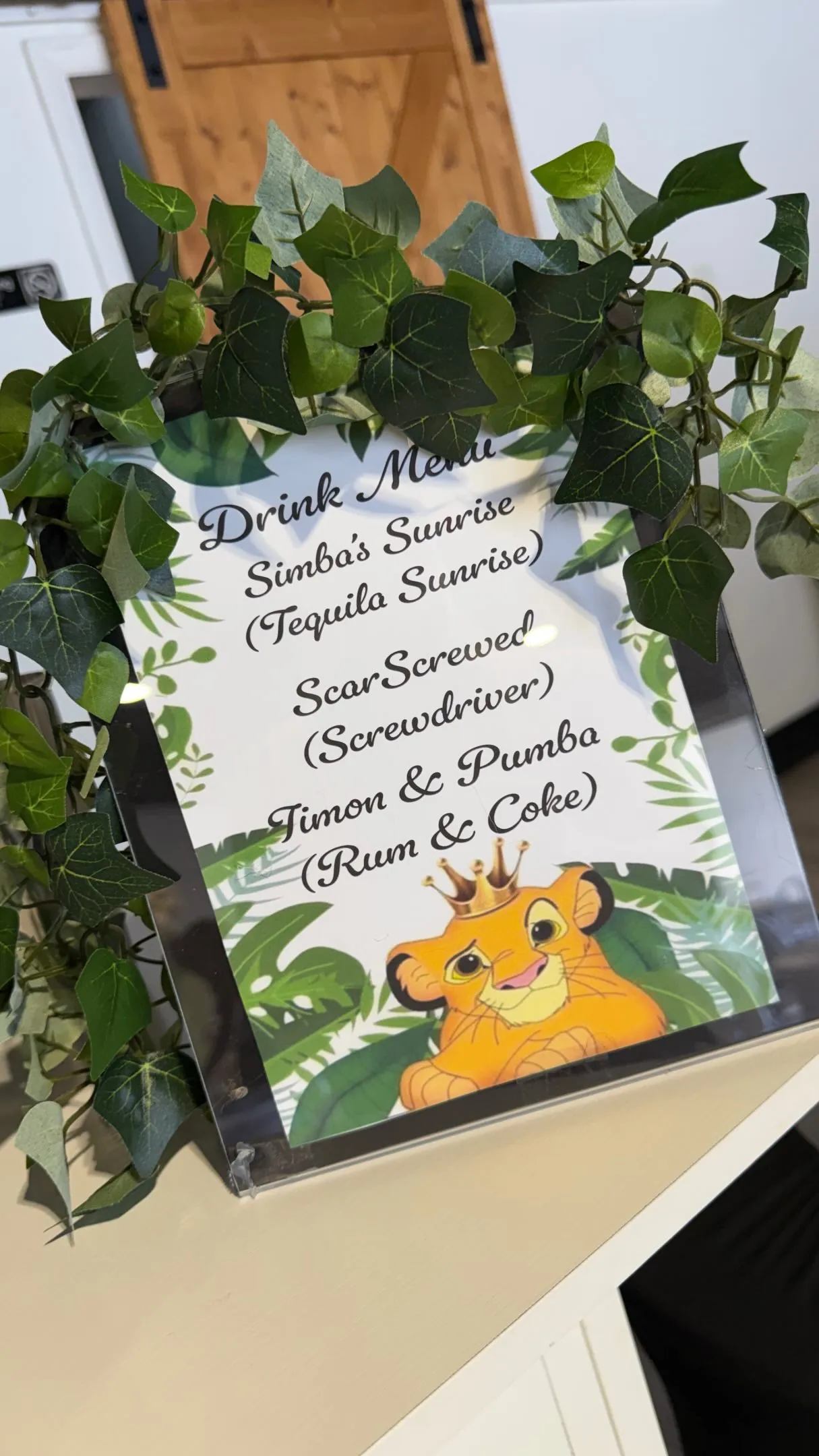 Lion King themed menu sign framed by tropical greenery