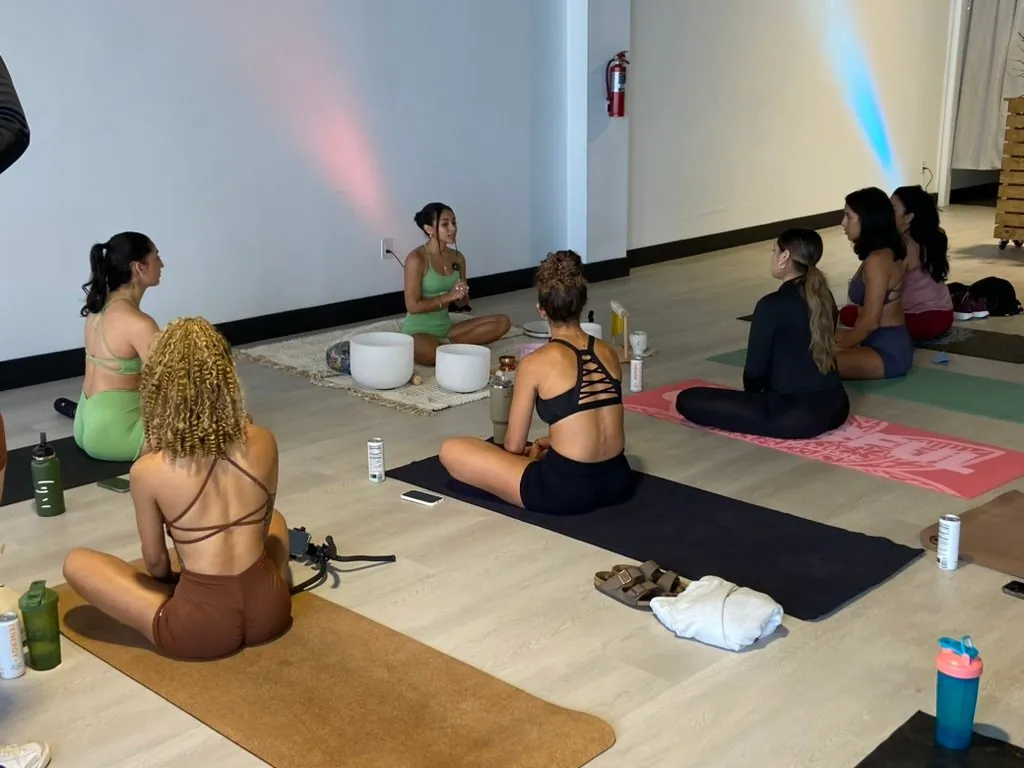 Participants seated on mats during a wellness session at Event Center Miami